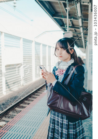 スマホを持って佇む女子高生 103436007