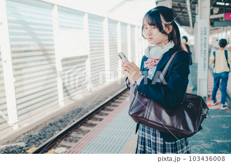 スマホを持って佇む女子高生 103436008