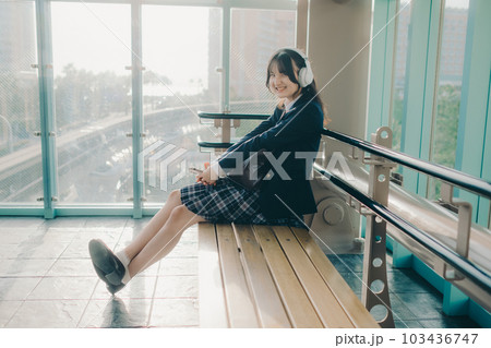 ベンチに座っている女子高生 103436747