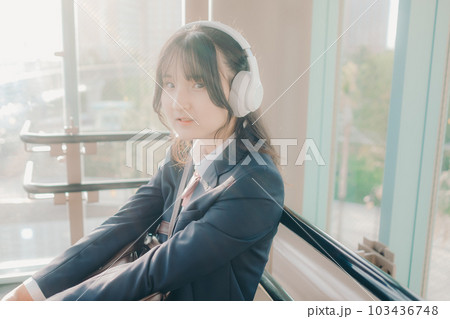 ベンチに座っている女子高生 103436748