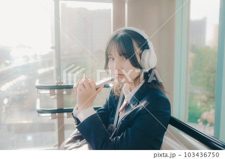 ベンチに座っている女子高生 103436750