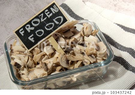 Frozen food sliced mushrooms champignon with blackboard wooden label and text FROZEN FOOD homemade. Harvesting concept. Stocking up vegetables for winter storage Healthy food 103437242