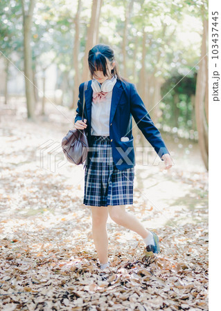 公園の落ち葉で遊ぶ女子高生 103437445