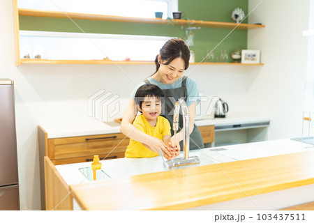 食器洗いをお手伝いする3歳の男の子 103437511