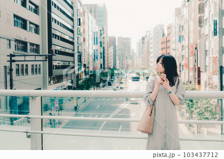 街中でスマホを持って佇む女性 街中でスマホを持って佇む女性 103437712