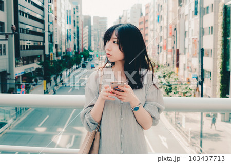 街中でスマホを持って佇む女性 街中でスマホを持って佇む女性 103437713