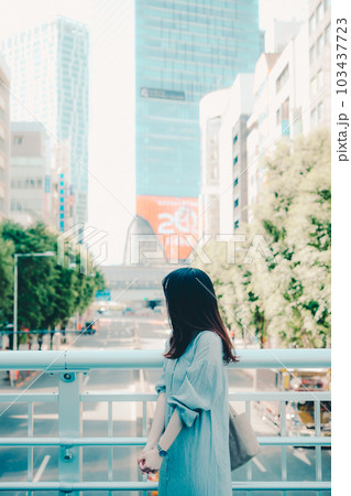 街中でスマホを持って佇む女性 103437723