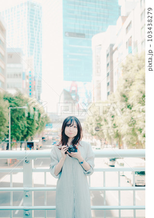 フィルムカメラを持って佇む女性 103438279