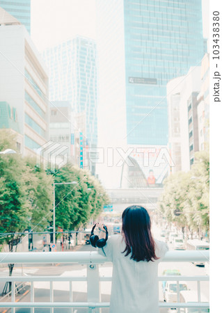 陸橋でヘッドフォンをしている女性 陸橋でヘッドフォンをしている女性 103438380
