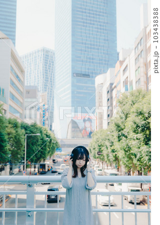 陸橋でヘッドフォンをしている女性 陸橋でヘッドフォンをしている女性 103438388