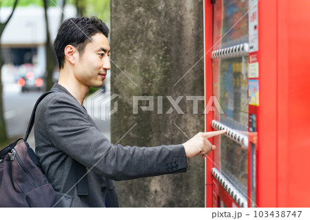 自販機で飲み物を買う男性 103438747