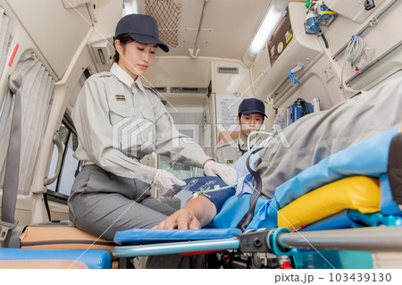 救急車で血圧を確認する救急隊員 救急車で血圧を確認する救急隊員 103439130