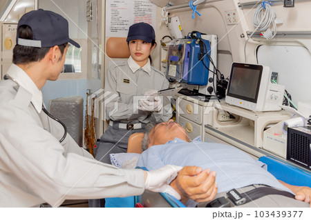 救急車で脈拍を確認する救急隊員 103439377
