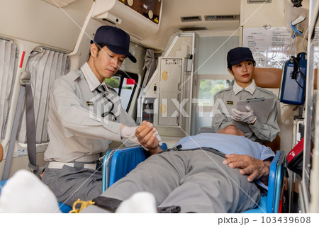 救急車で脈拍を確認する救急隊員 103439608