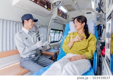 救急車を呼んだ体調不良の女性に質問をする救急隊員 103439637