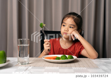 Little cute kid girl refusing to eat healthy vegetables. Children do not like to eat vegetables. Little cute kid girl refusing to eat healthy vegetables. Children do not like to eat vegetables. 103439724