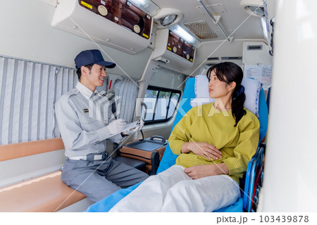 救急車を呼んだ体調不良の女性に質問をする救急隊員 103439878