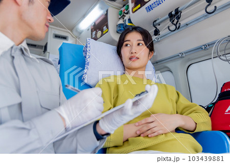 救急車を呼んだ体調不良の女性に質問をする救急隊員 救急車を呼んだ体調不良の女性に質問をする救急隊員 103439881