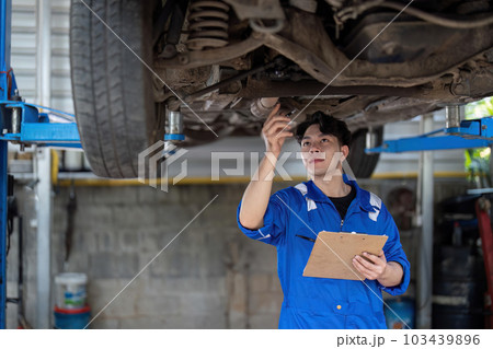Vehicle service maintenance asian man checking under car condition in garage. Automotive mechanic maintenance checklist document. Car repair service concept 103439896