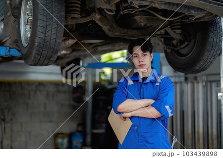 Vehicle service maintenance asian man checking under car condition in garage. Automotive mechanic maintenance checklist document. Car repair service concept 103439898