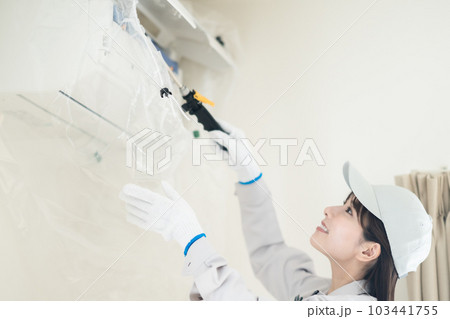 エアコン清掃をする女性業者スタッフ 103441755