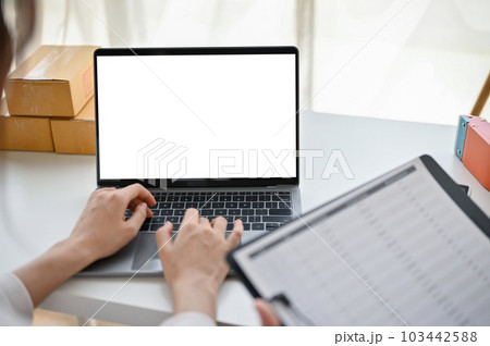 A female online business owner or website admin confirming customer orders on the website 103442588
