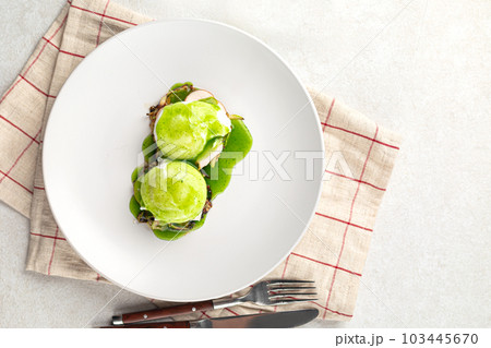 Portion of breakfast with poached egg and sauce 103445670