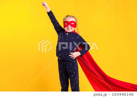 Funny little power superhero child (girl) in a red raincoat and a mask. Superhero concept. 103446146