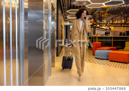 Good-looking young business woman with a suitcase in the hotel Good-looking young business woman with a suitcase in the hotel 103447868