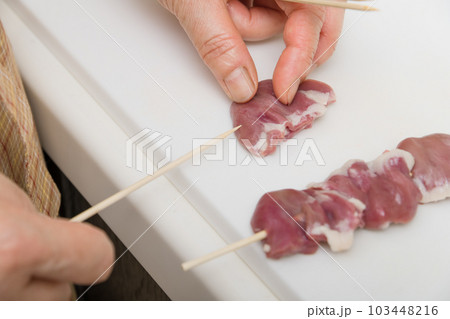 【焼き鳥ハツの串打ちをする主婦】 103448216