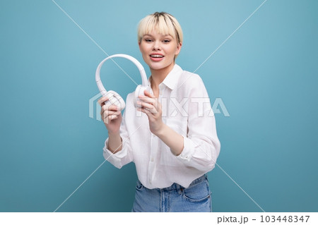 portrait of a stylish young pretty blond secretary woman dressed in a white blouse listening to 103448347