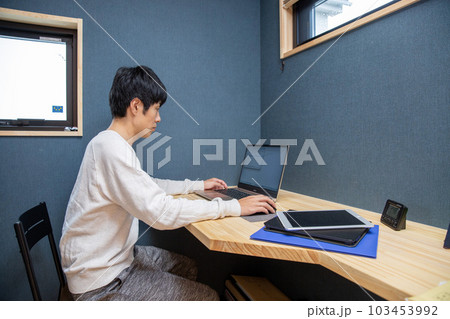 自宅のワークスペースで仕事する日本人男性 103453992