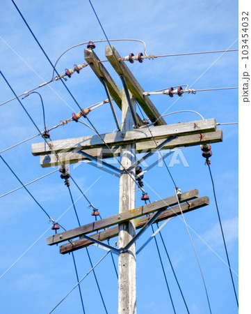 Electric pole and wires, wood electricty pole on blue sky background. 103454032