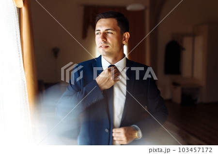 Stylish groomsmen. Businessman. Luxury man in suit in room. Groom morning preparation. Wedding day. 103457172