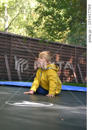 A boy on a trampoline in the garden. . High quality photo 103457769