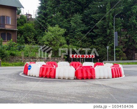 roundabout with white and red plastic barriers roundabout with white and red plastic barriers 103458436
