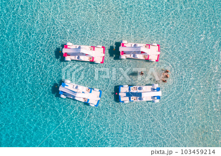 Aerial view of catamarans, swimming people in blue sea in summer Aerial view of catamarans, swimming people in blue sea in summer 103459214