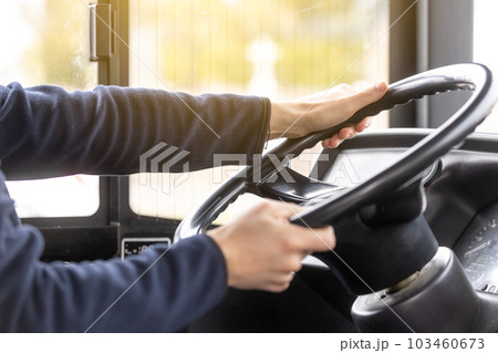 Close up of bus driver hands on the steering wheel during driving the bus, public transport concept 103460673