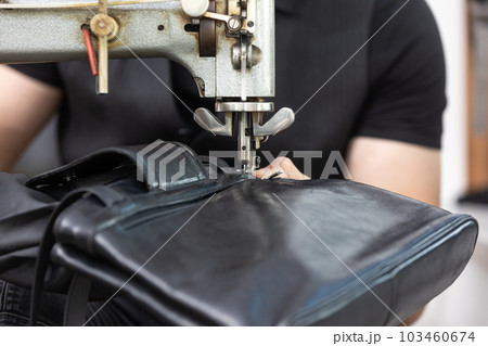 Black leather bag repair in the tailoring studio, leatherworking concept Black leather bag repair in the tailoring studio, leatherworking concept 103460674