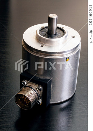 Metal encoder on a black wooden table 103460915
