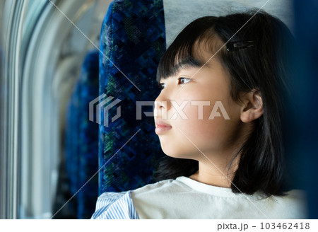 電車の窓から外を見る10代の女性 103462418