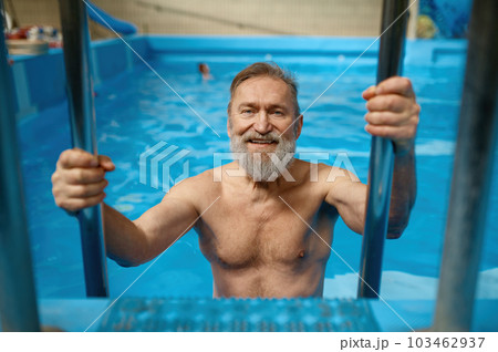 Portrait of good-looking fit senior man getting out from swimming pool Portrait of good-looking fit senior man getting out from swimming pool 103462937