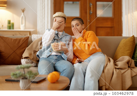 Young lesbian woman couple watching scary movie at home 103462978