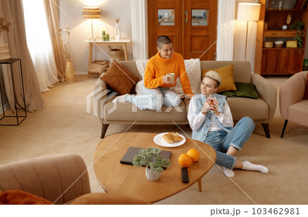 Young lgbt woman couple drinking coffee planning future while resting at home 103462981