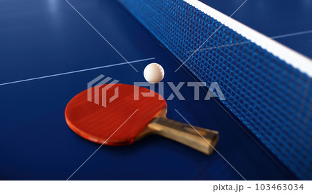 Tennis racket and ball on ping-pong table with net prepared for game 103463034