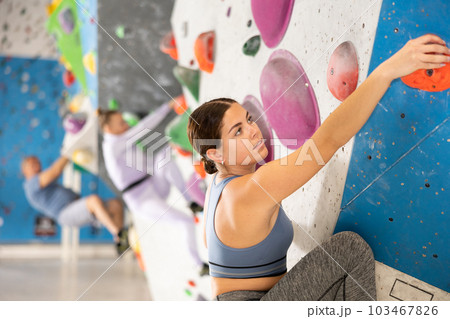 Young woman practicing rock climbing on climbing wall Young woman practicing rock climbing on climbing wall 103467826