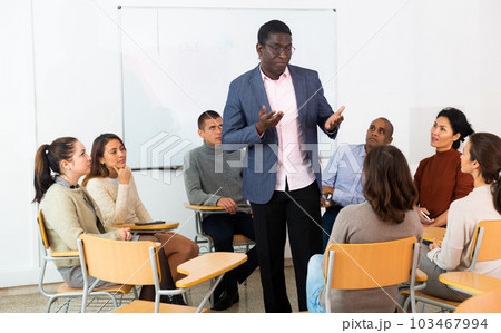 Portrait of man giving speech during therapy session in support group Portrait of man giving speech during therapy session in support group 103467994
