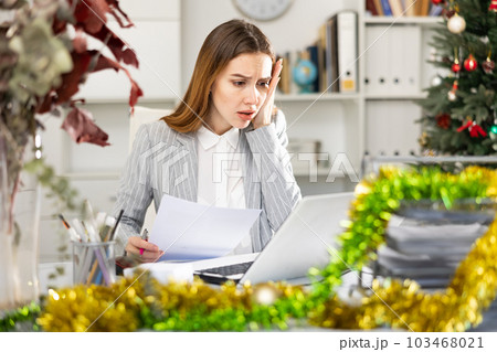 Sad woman manager working in Christmas decorated office 103468021