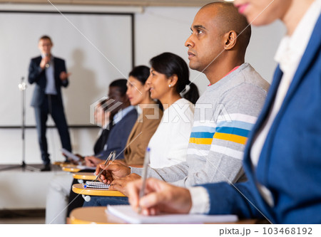 Hispanic man listening to lecturer during business training 103468192