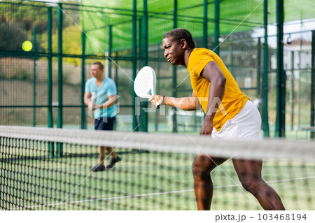 African american man playing padel tennis 103468194